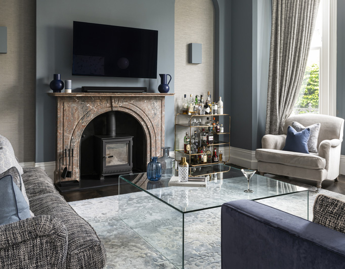 Luxury interior design in London – blue living room with glass coffee table and textured rug