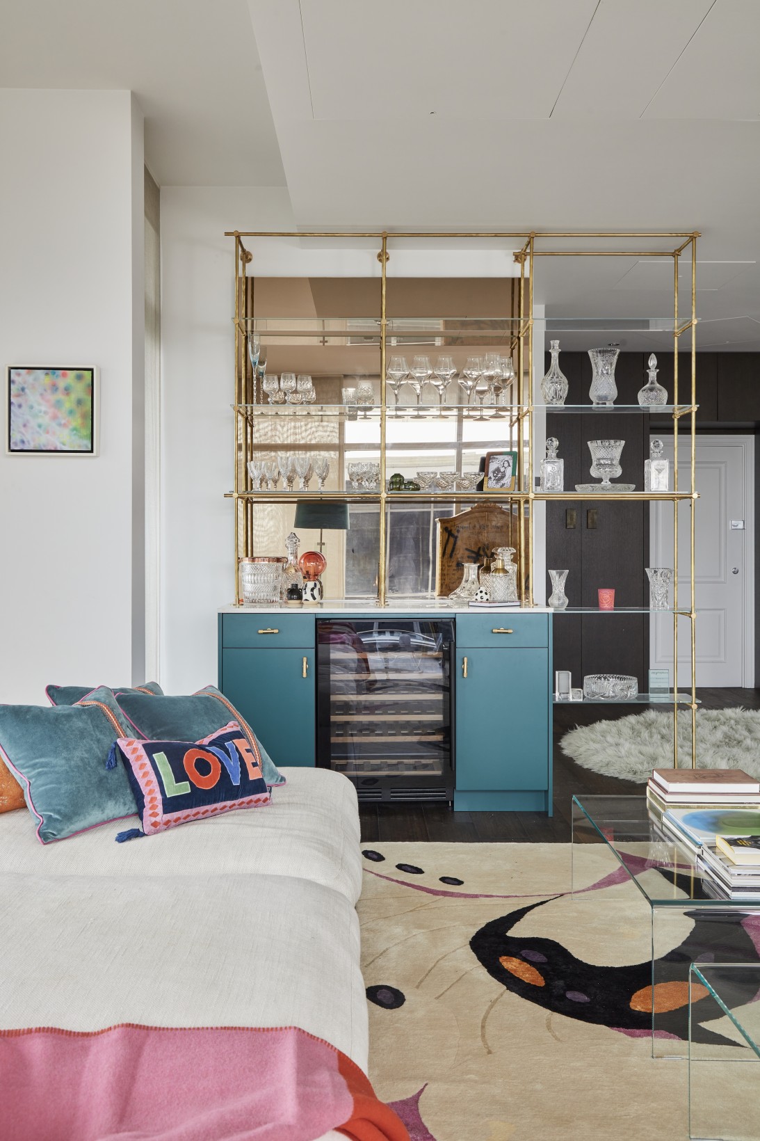 Bespoke teal bar unit with glass shelves and crystal collection in London penthouse media room