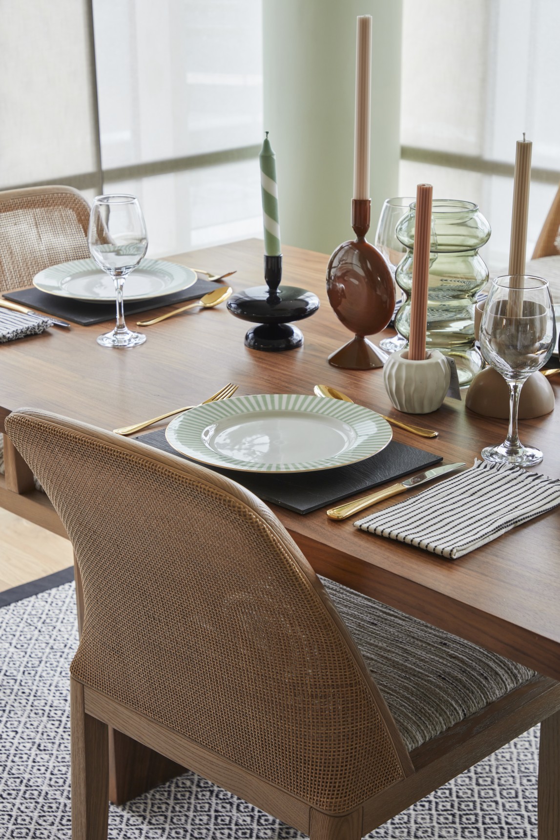 Dining table styling with cane and wood chair, contemporary glassware and striped candles in London penthouse