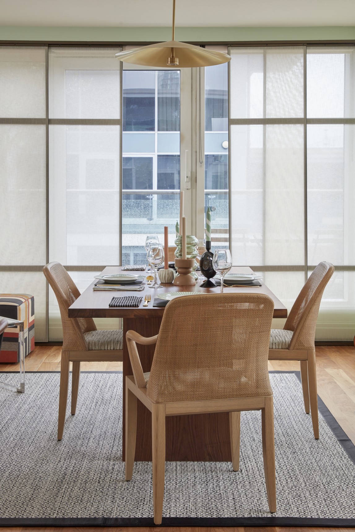 Dining area with cane-back chairs, shoji sliding blind panels and modern brass pendant light in luxury penthouse
