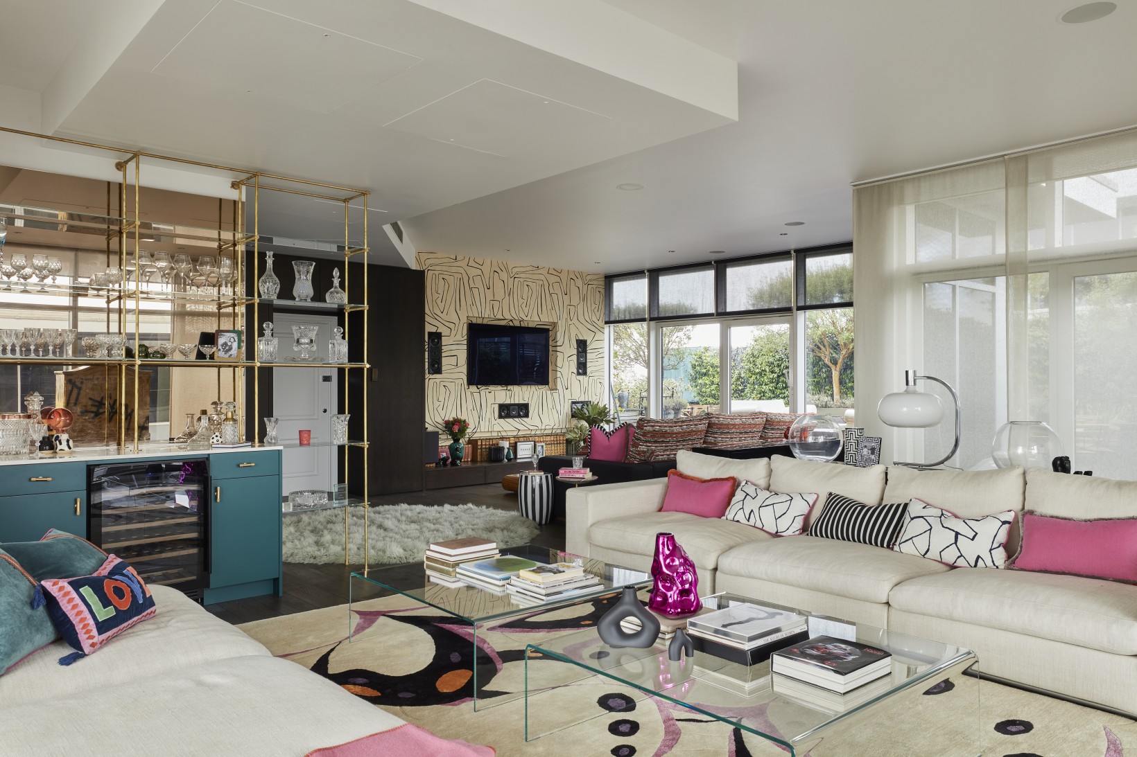 Open-plan London penthouse party room with bar, patterned rug, and spacious lounge