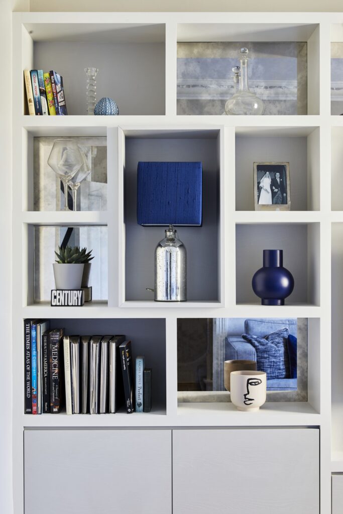 Bespoke media unit with open shelving, curated objects, and integrated storage in a Wandsworth living room by Emma Green Design.