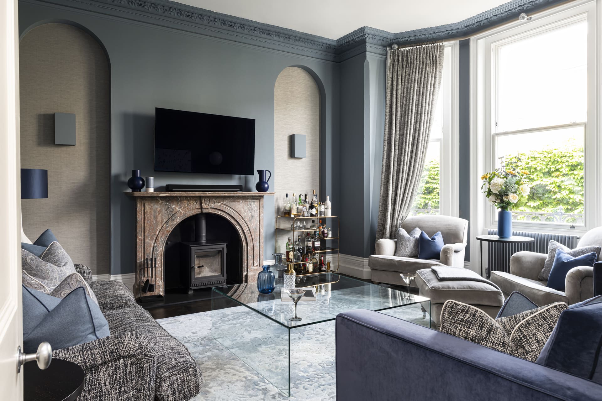 Formal living room interior in a Wandsworth home featuring a period fireplace, bespoke joinery, and blue-toned furnishings designed by Emma Green Design.