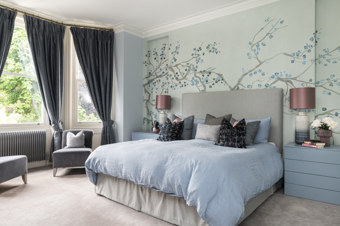 Soft blue bedroom with hand-painted mural and layered textiles