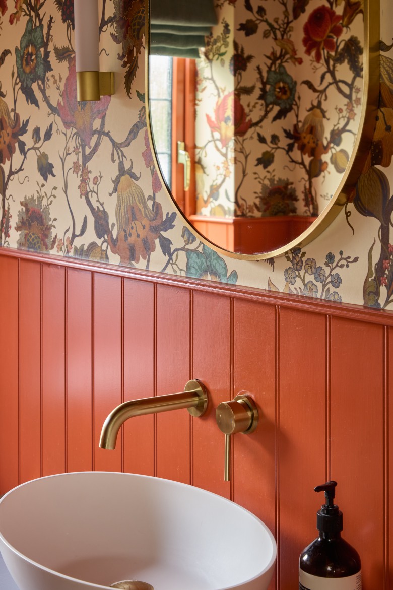 Brass tap basin and mirror detail in cloakroom