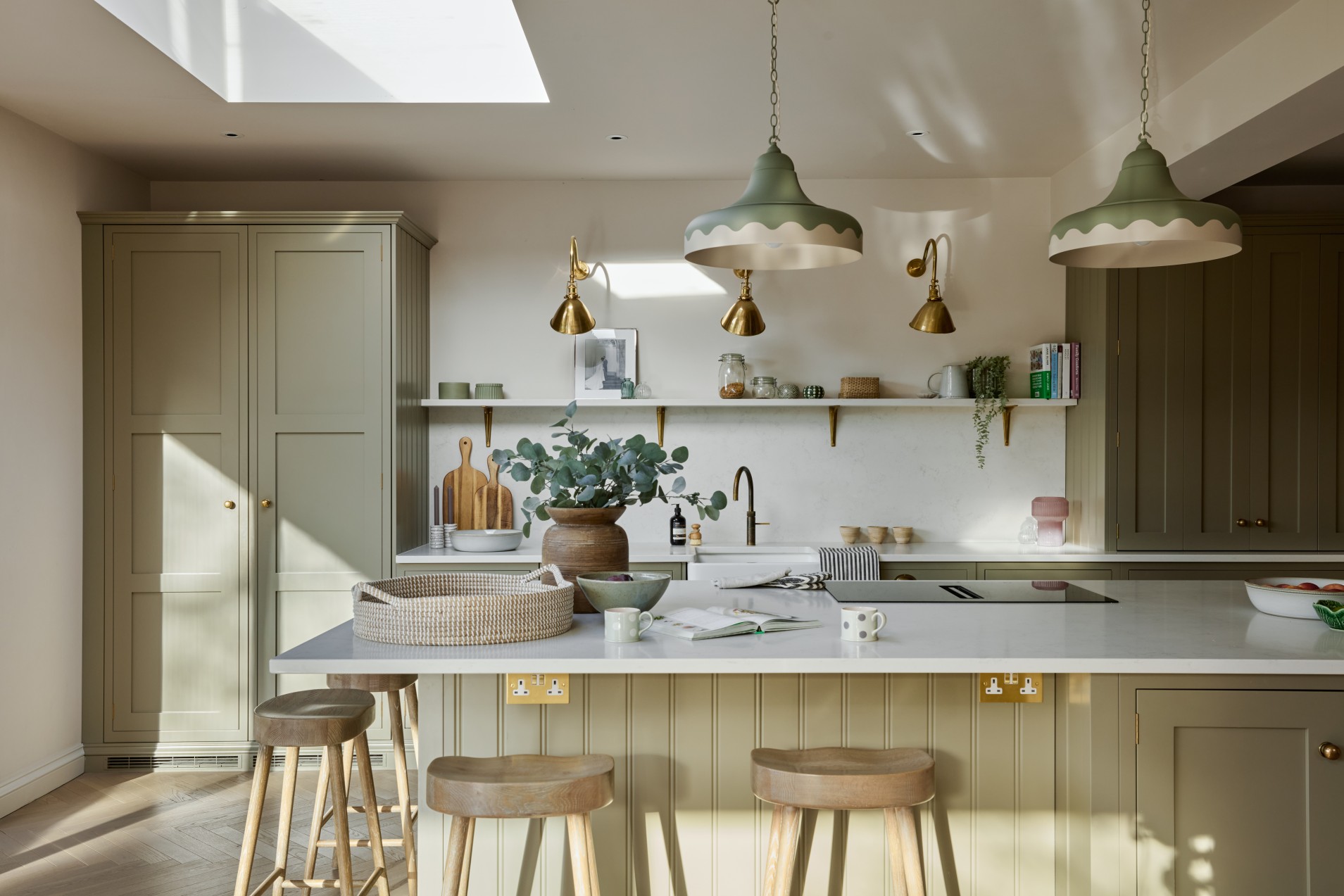 Kitchen island with wooden stools and green cabinetry in countryside home