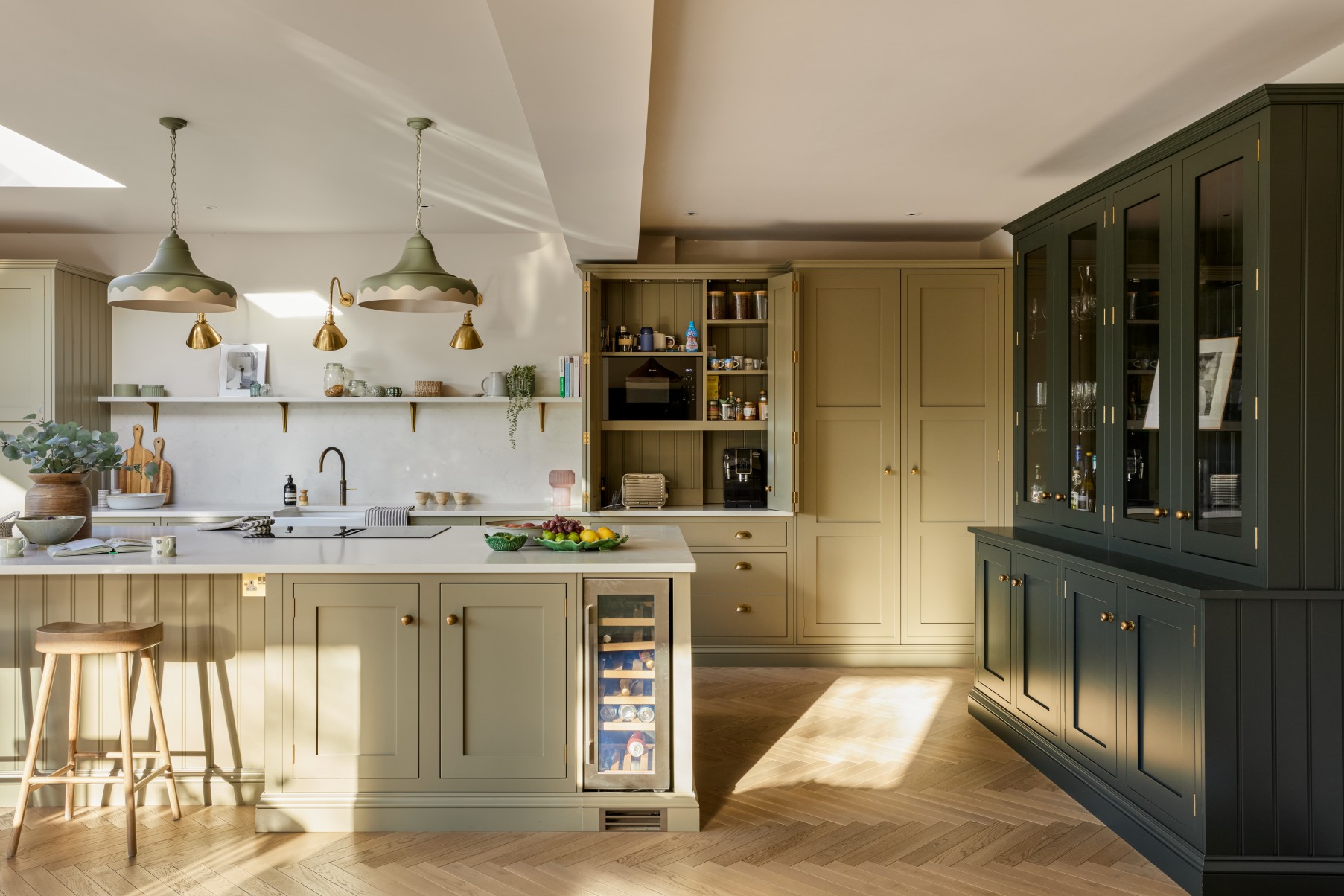 Bespoke pantry cupboard with concealed appliances in green kitchen